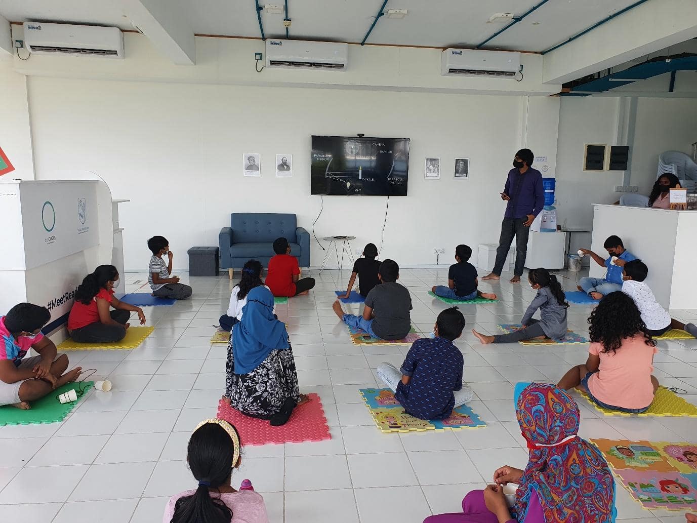 Children participating in class about the physics of how camera's work in the circle space maldives